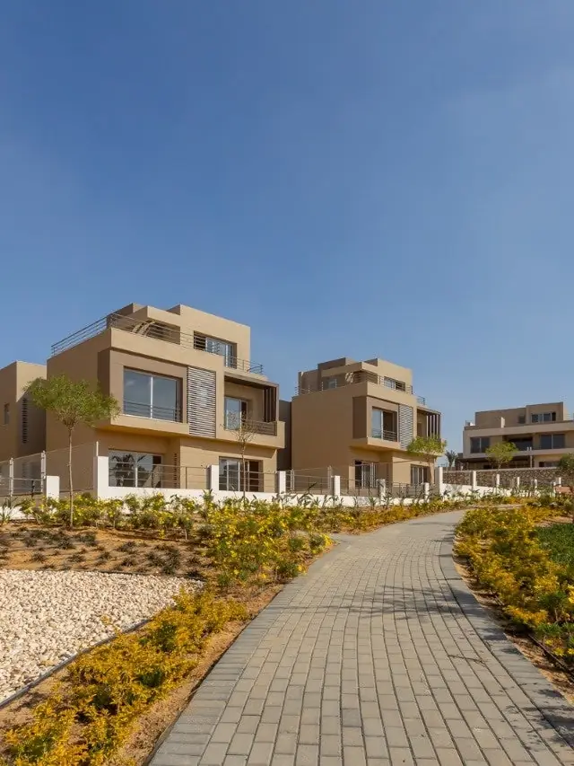 Aerial view of villas, palm trees, and a pool at Palm Hills New Cairo.